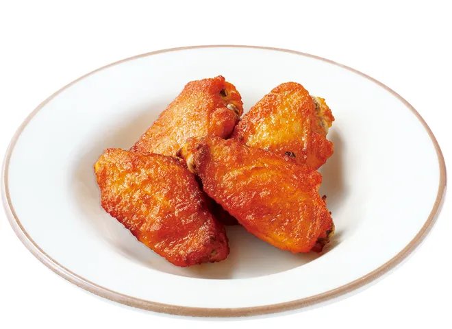 白い皿に骨付きの手羽が数本盛られた辛味チキン