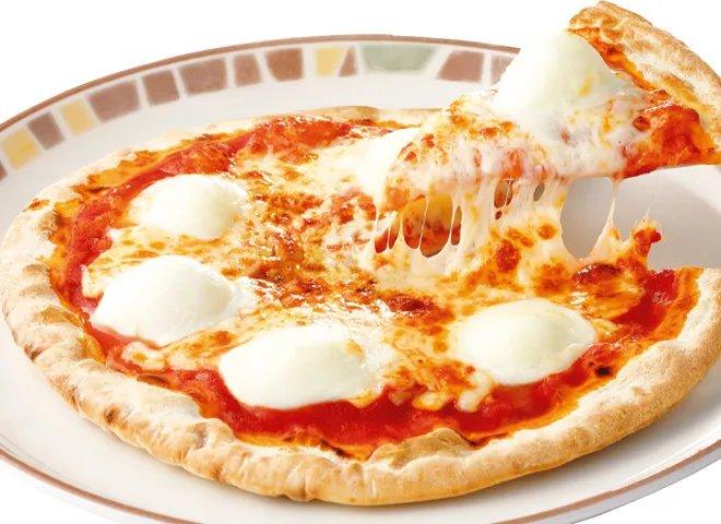 トマトソースの上に白いモッツァレラが点々とのった丸いマルゲリータピザ