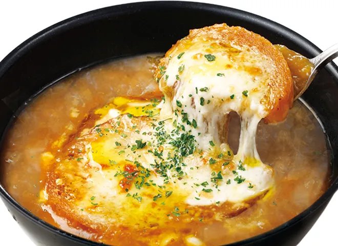 スープの上のパンにとろけたチーズがのった、器いっぱいのたまねぎのズッパ