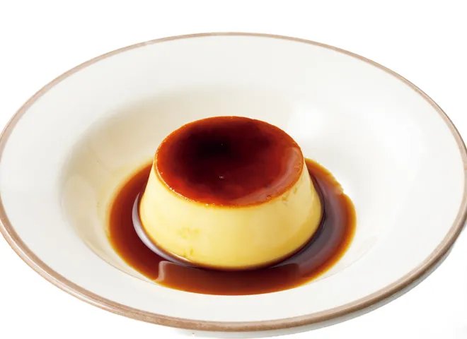 白い皿の上に、カラメルソースをまとった小ぶりのイタリアンプリン