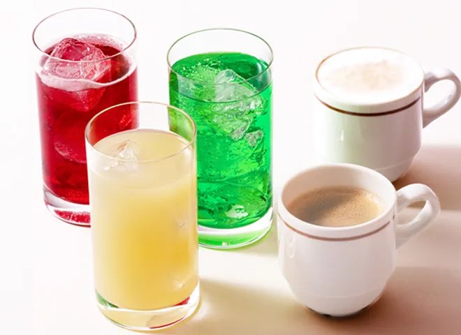 ソフトドリンクのグラスとカプチーノ・コーヒーのカップが並ぶドリンクバーの飲み物